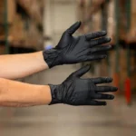 farm worker with single-use waterproof black disposable nitrile gloves for warehouse work